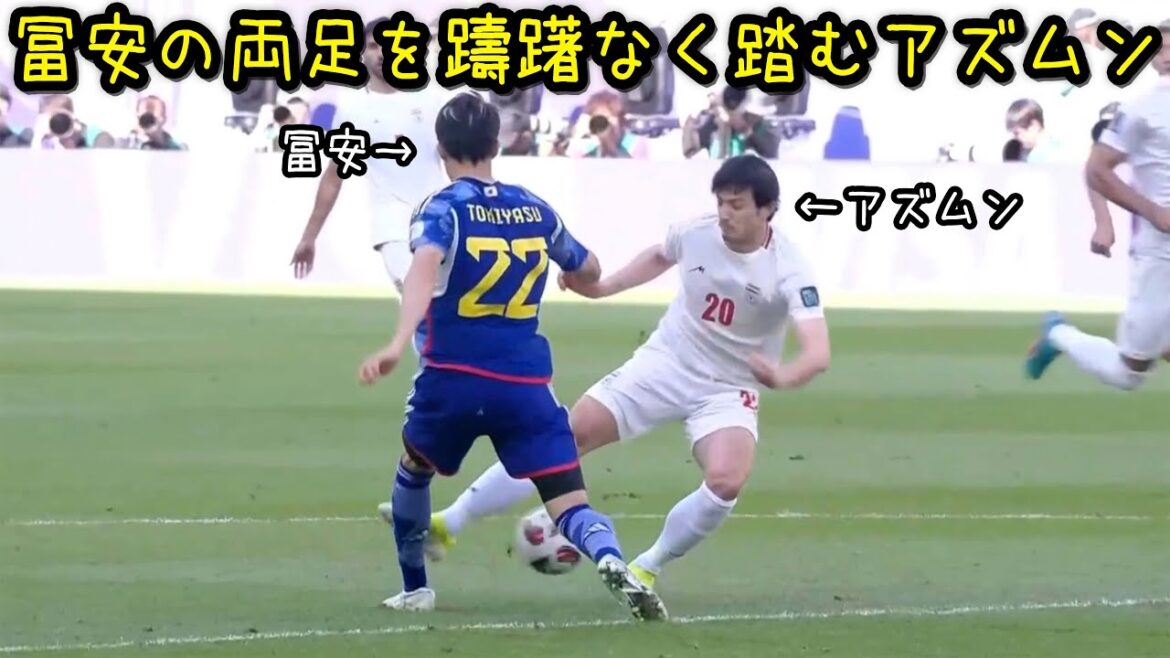Takehiro Tomiyasu gets his feet stepped on by Azmun during the match against Iran